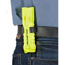 Bright yellow flashlight attached to belt using a belt clip accessory.